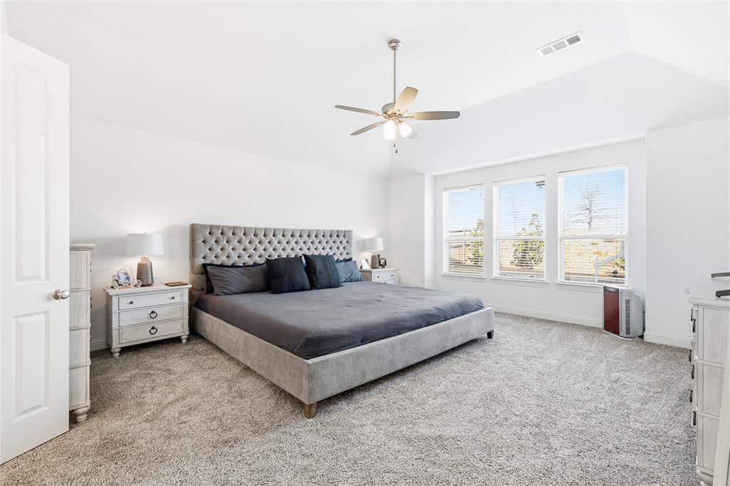 6508 Cooper Creek Road Flower Mound, TX 76226 - Photo 16 of 39 a spacious bedroom with a bed and a chandelier