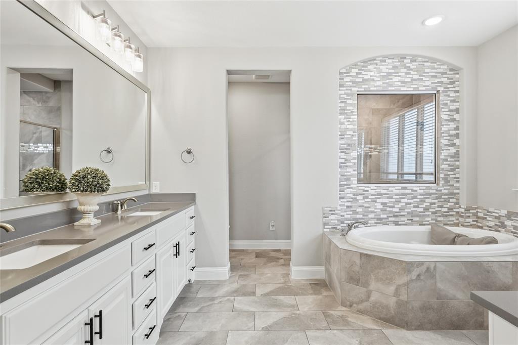 6508 Cooper Creek Road Flower Mound, TX 76226 - Photo 18 of 39 a bathroom with a granite countertop sink a toilet a mirror and bathtub