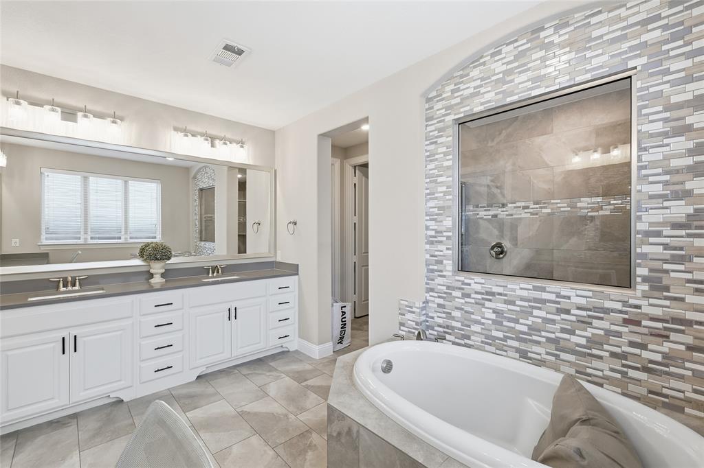 6508 Cooper Creek Road Flower Mound, TX 76226 - Photo 19 of 39 a bathroom with a granite countertop tub a sink and a large mirror