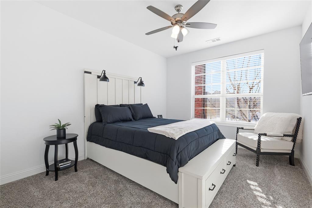 6508 Cooper Creek Road Flower Mound, TX 76226 - Photo 22 of 39 a bedroom with a bed and a chandelier