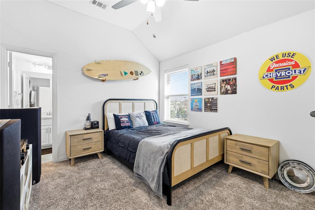 6508 Cooper Creek Road Flower Mound, TX 76226 - Photo 23 of 39 a bedroom with a bed and a chandelier