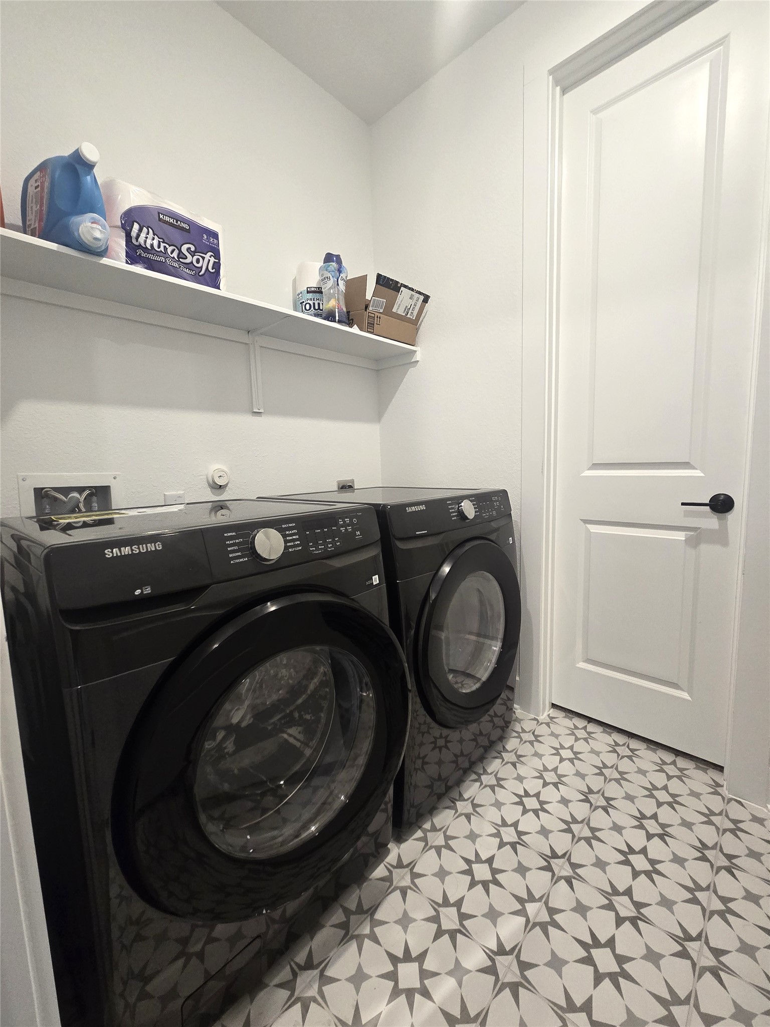 124 Ribera Drive Liberty Hill, TX 78642 - Photo 14 of 40 A well-appointed utility area featuring contemporary appliances and patterned floor tiles.