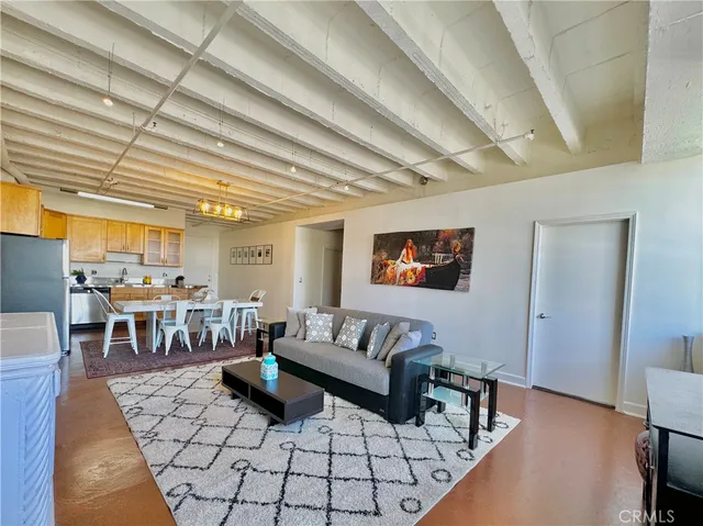 a living room with lots of furniture and a dining table with wooden floor