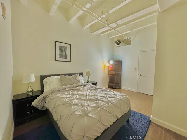 a bedroom with a bed and a lamp with the wall