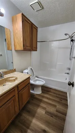 a bathroom with a granite countertop sink toilet and shower