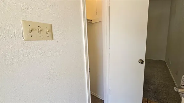 an empty room with closet and a chandelier fan