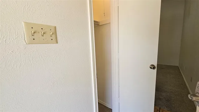 an empty room with closet and a chandelier fan