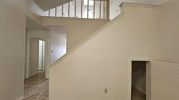 a view of a hallway with wooden floor and staircase