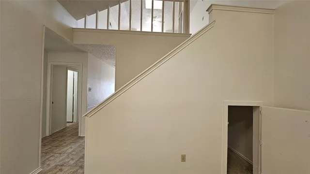 a view of a hallway with wooden floor and staircase