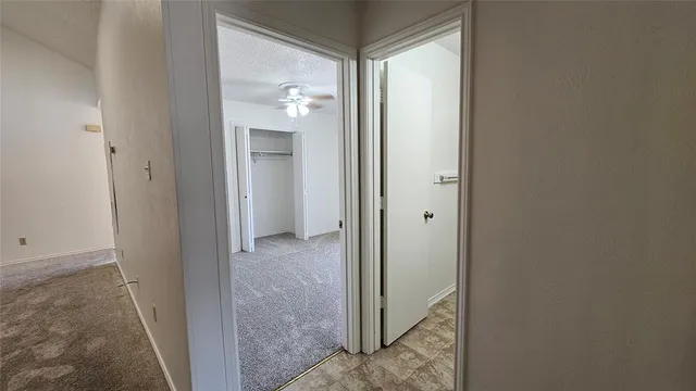 a view of an empty room with a chandelier fan