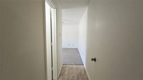 an empty room with closet and a ceiling fan