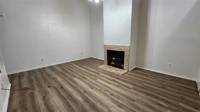 a view of empty room with wooden floor and fireplace