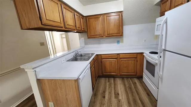 a kitchen with a sink a refrigerator and cabinets