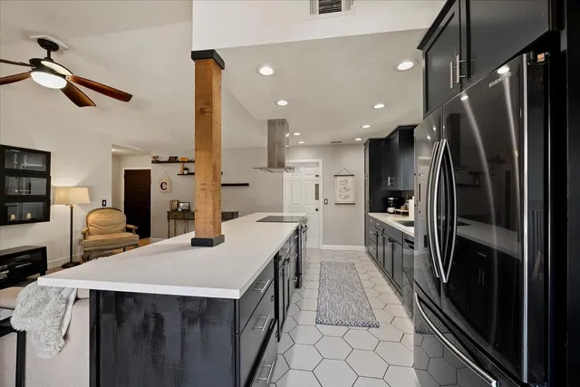 a kitchen with kitchen island a sink appliances and cabinets
