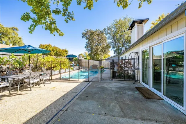 a view of a patio with table and chairs with wooden floor and fence