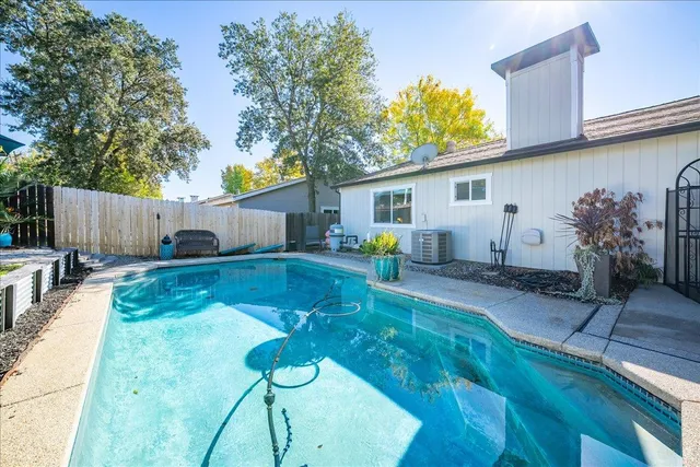 a view of a patio with a table and chairs under an umbrella with large trees