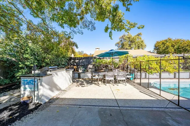 a view of a patio with a table and chairs under an umbrella