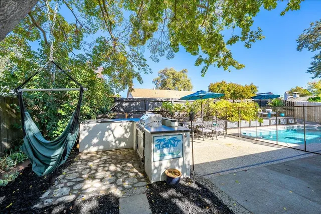 a view of a patio with dining table and chairs with a small yard
