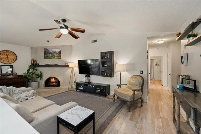 a living room with furniture a fireplace and flat screen tv