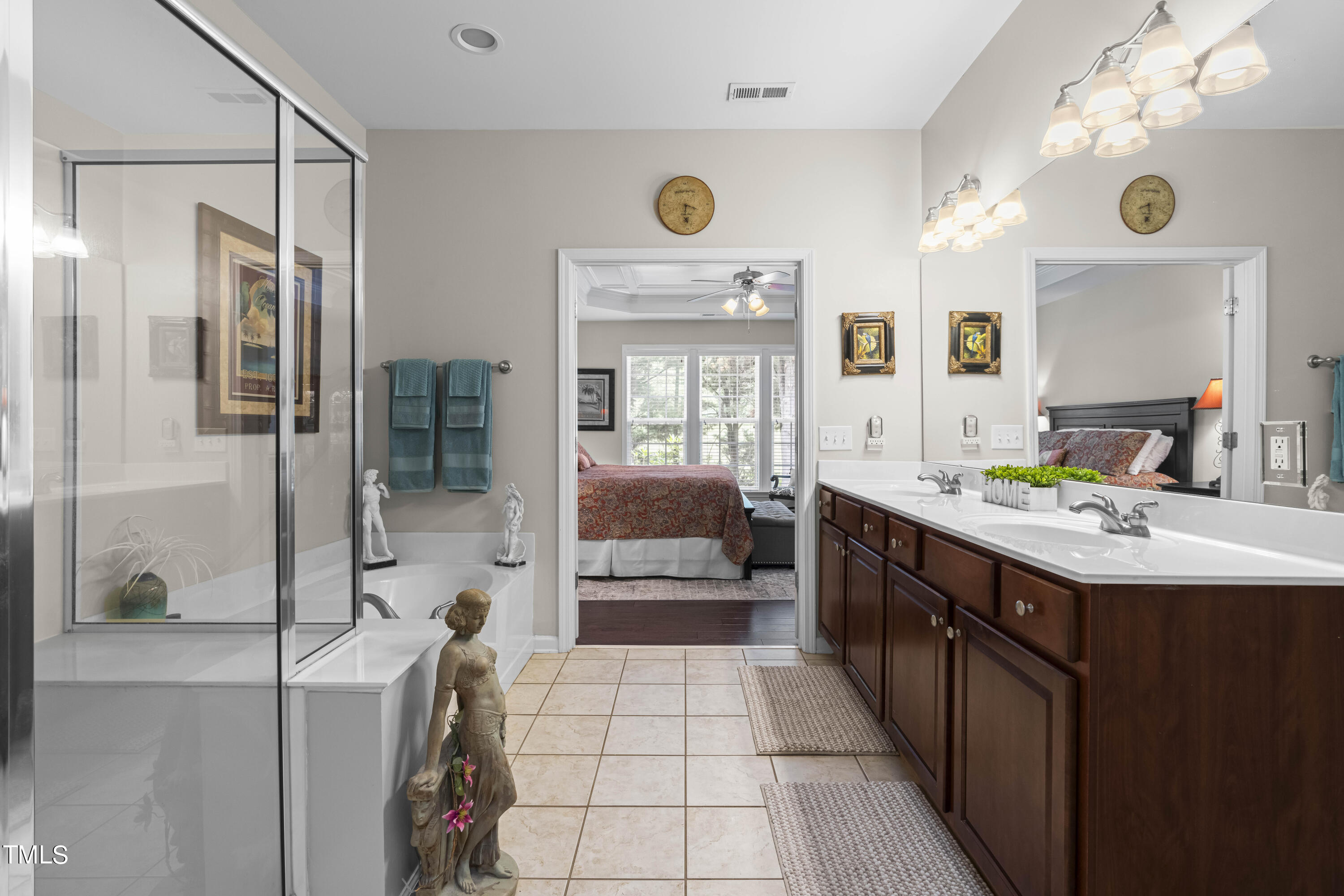 4604 Manassa Pope Lane Raleigh, NC 27612 - Photo 21 of 43 a spacious bathroom with a double vanity sink a large mirror and a shower