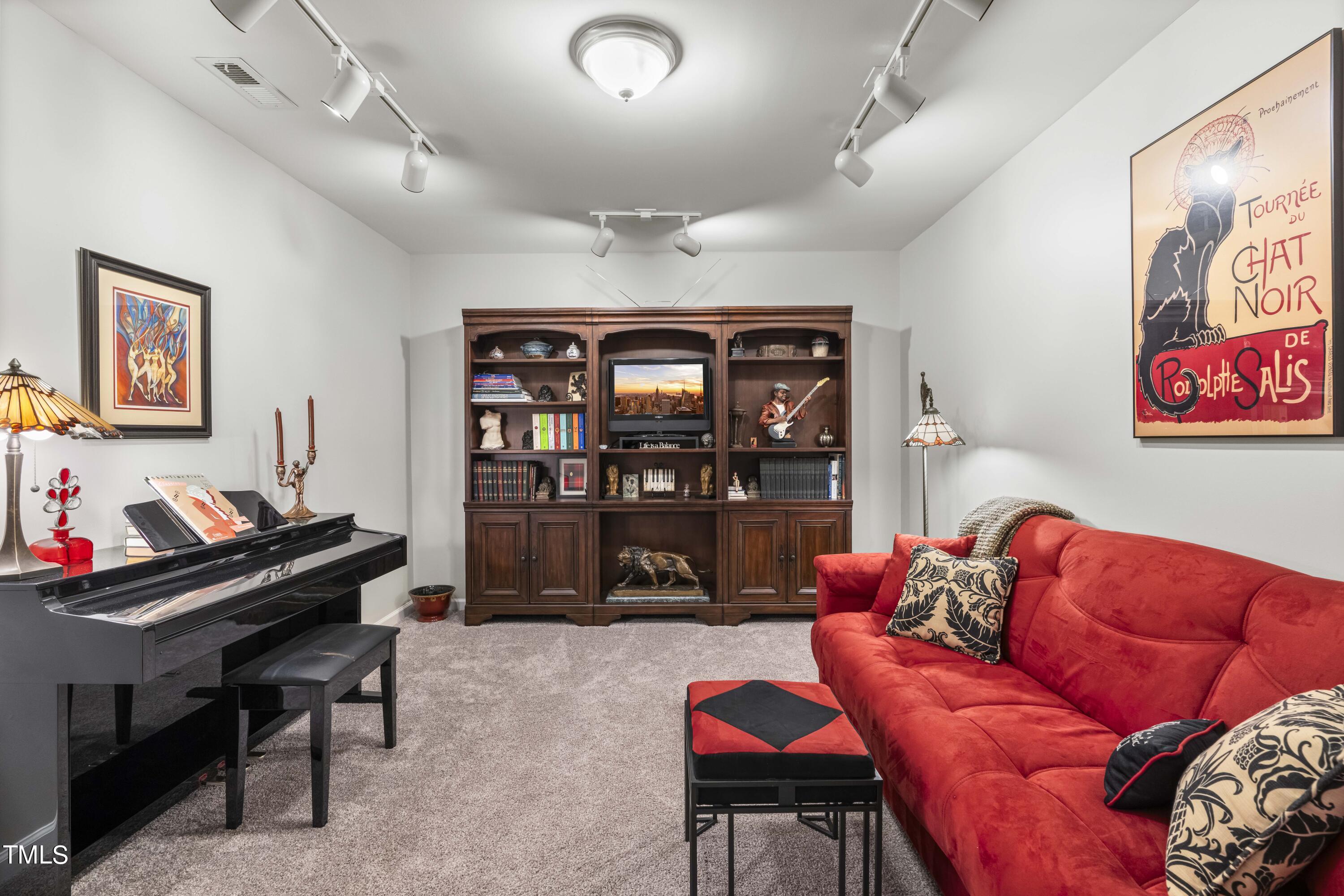 4604 Manassa Pope Lane Raleigh, NC 27612 - Photo 32 of 43 a living room with furniture a rug and a bookshelf