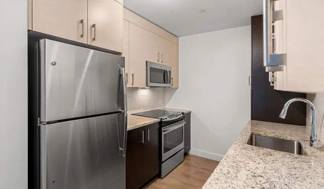 a kitchen with granite countertop a refrigerator and a sink