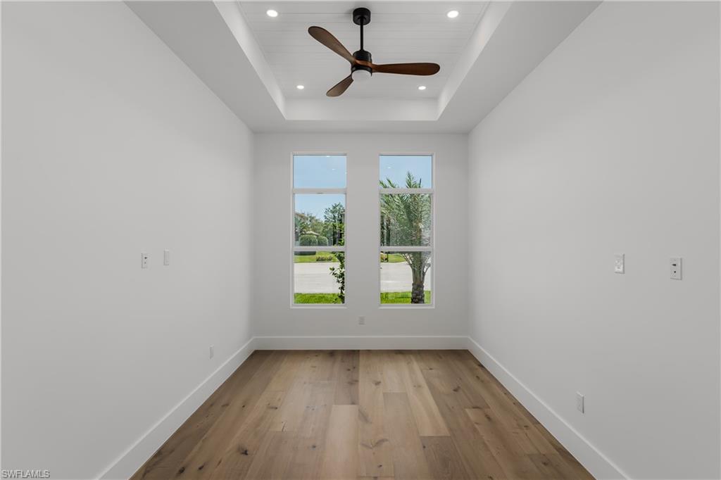 2854 Coach House Way Naples, FL 34105 - Photo 19 of 45 Unfurnished room with recessed lighting, light wood-style flooring, baseboards, ceiling fan, and a raised ceiling