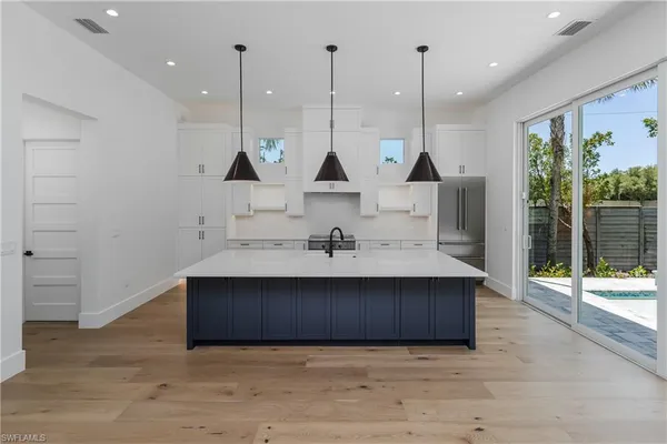 a view of kitchen with stainless steel appliances granite countertop cabinets and wooden floor