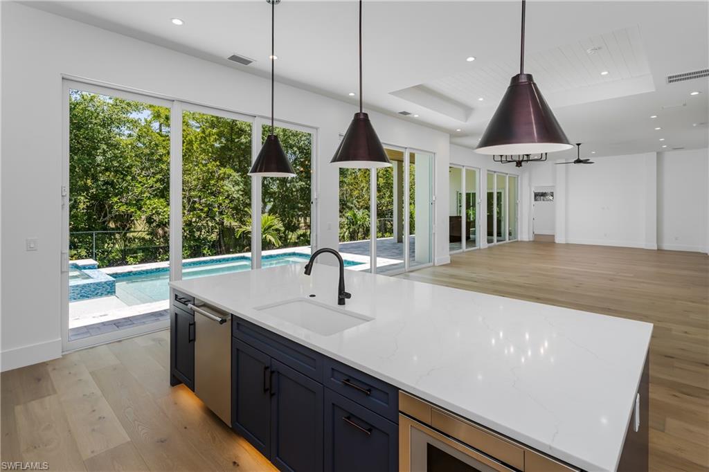 2854 Coach House Way Naples, FL 34105 - Photo 45 of 45 Kitchen featuring a sink, stainless steel dishwasher, light wood-style flooring, open floor plan, and recessed lighting