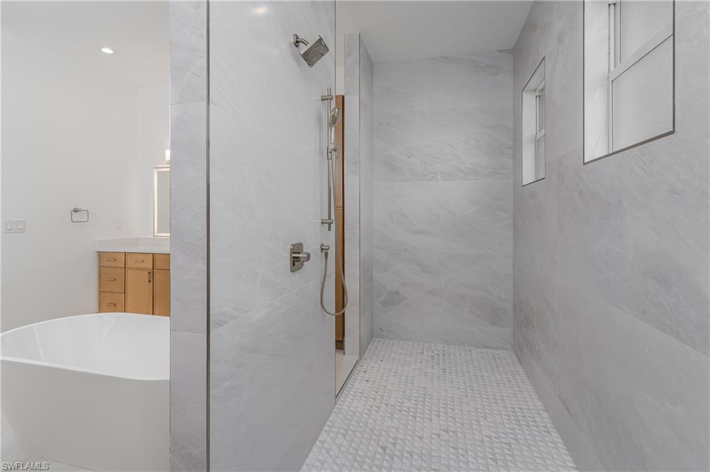 2854 Coach House Way Naples, FL 34105 - Photo 28 of 45 Bathroom featuring a marble finish shower, a soaking tub, and vanity