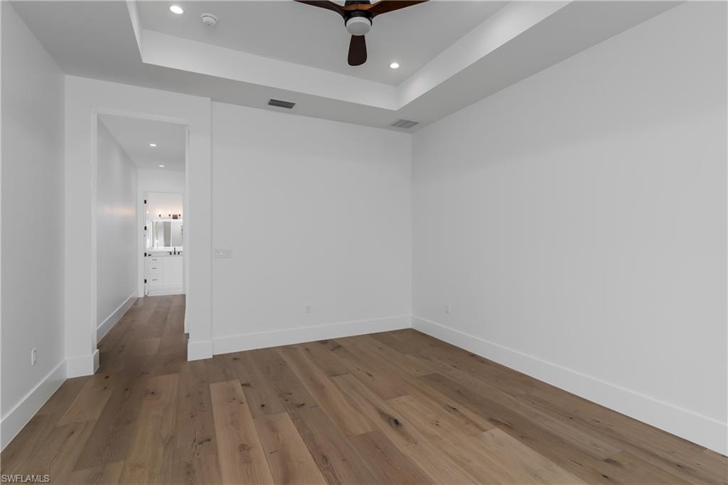 2854 Coach House Way Naples, FL 34105 - Photo 29 of 45 Unfurnished room with recessed lighting, a raised ceiling, wood finished floors, baseboards, and ceiling fan