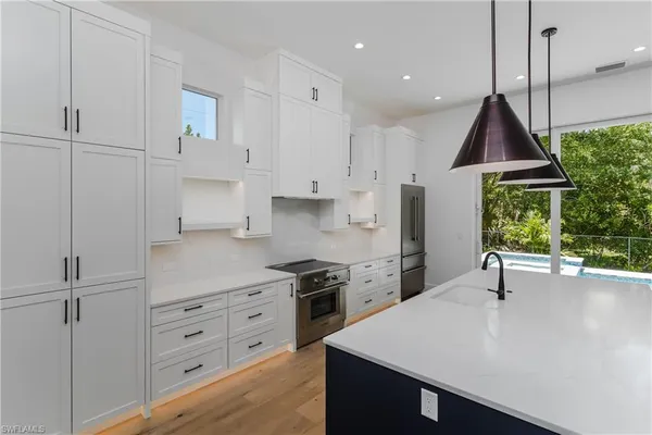 a kitchen with kitchen island a counter top space a sink stainless steel appliances and cabinets