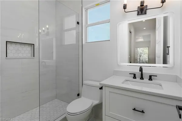 a bathroom with a sink a toilet and shower
