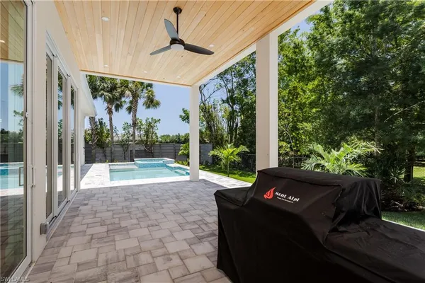 a view of a patio with a table chairs and a backyard