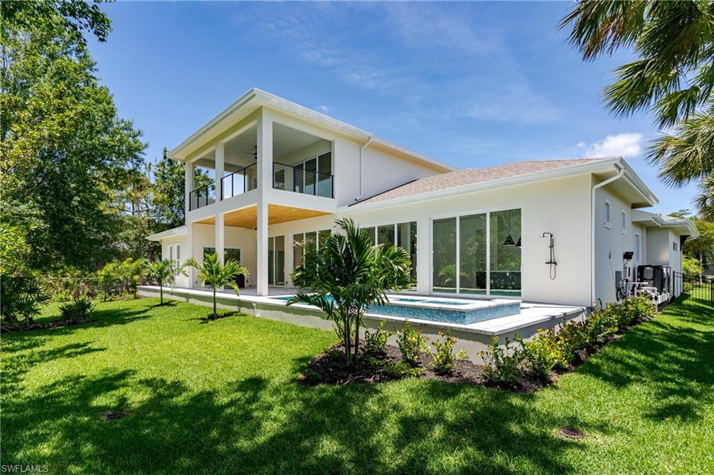 2854 Coach House Way Naples, FL 34105 - Photo 36 of 45 Back of property with a balcony, stucco siding, and an in-ground hot tub
