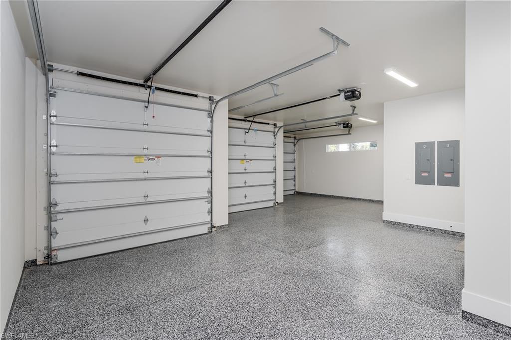 2854 Coach House Way Naples, FL 34105 - Photo 37 of 50 Garage with electric panel, a garage door opener, and baseboards