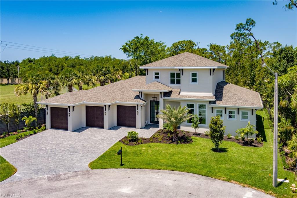 2854 Coach House Way Naples, FL 34105 - Photo 38 of 50 View of front of property with decorative driveway, a garage, a shingled roof, and a front yard