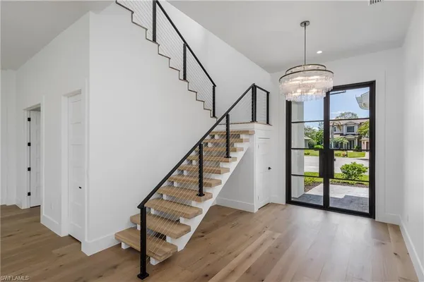 a view of entryway and hall with wooden floor