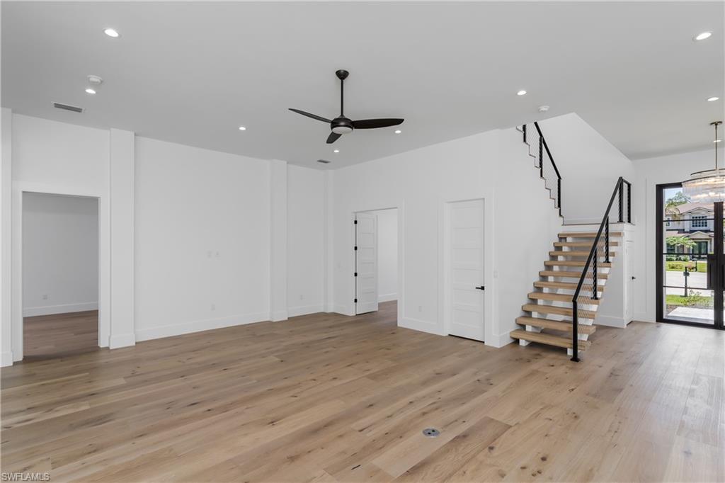 2854 Coach House Way Naples, FL 34105 - Photo 7 of 50 Unfurnished living room featuring stairway, a ceiling fan, recessed lighting, light wood-style floors, and baseboards