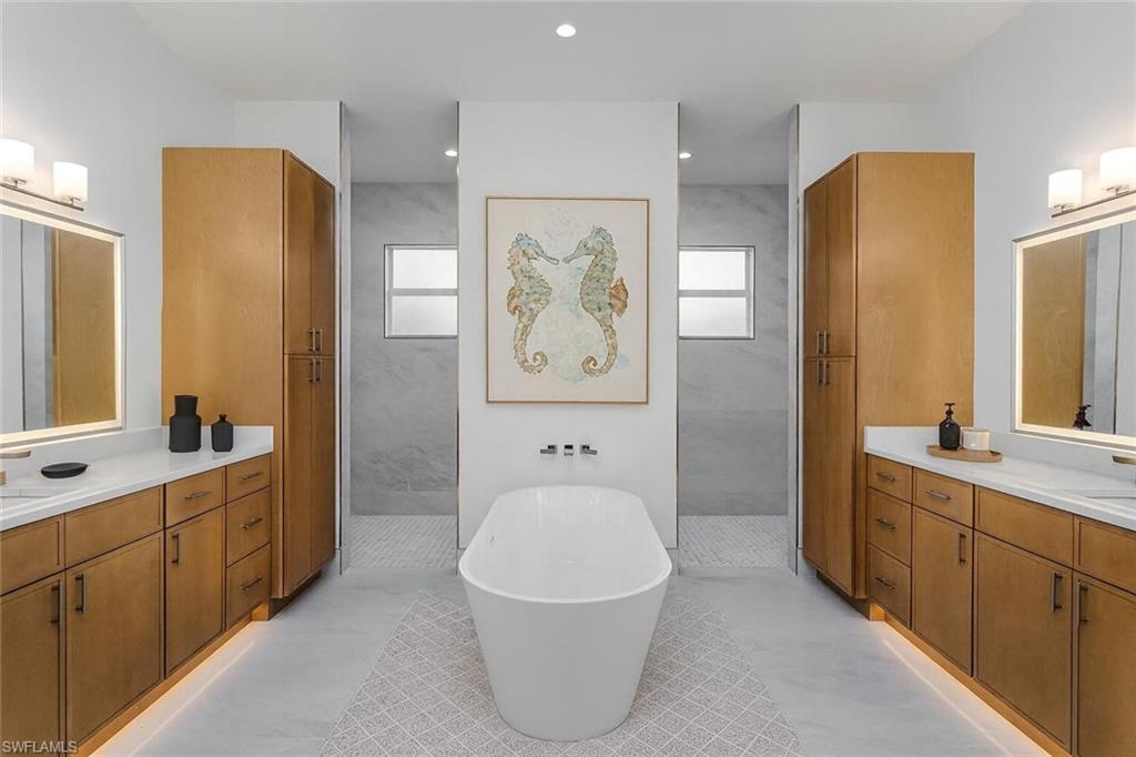 2854 Coach House Way Naples, FL 34105 - Photo 10 of 45 Bathroom featuring a soaking tub, two vanities, healthy amount of natural light, and recessed lighting