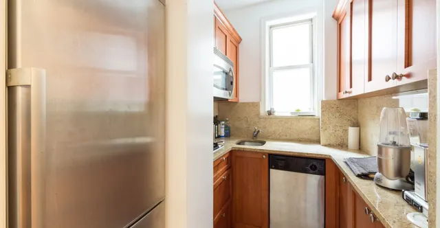 a utility room with stainless steel appliances granite countertop a refrigerator and a window