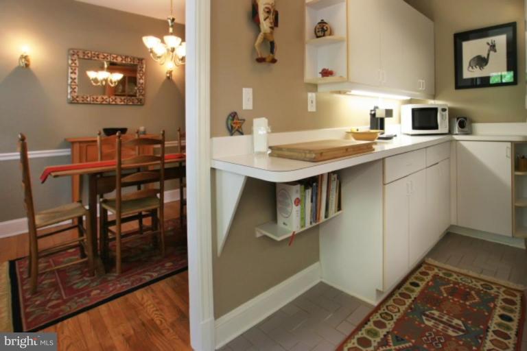 212 Dunkirk Road Baltimore, MD 21212 - Photo 21 of 30 a kitchen with kitchen island a stove a sink and a refrigerator with wooden floor