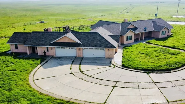 a aerial view of a house with a yard and lake view