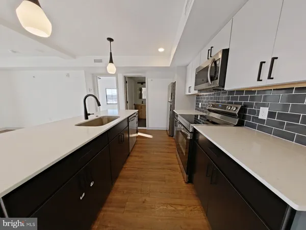 a kitchen with stainless steel appliances a sink stove and cabinets