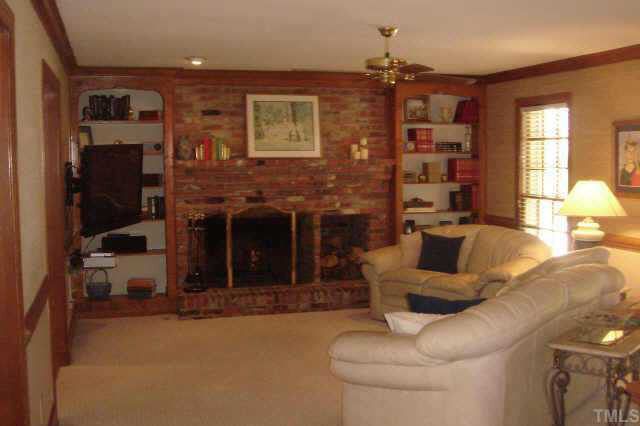 Living room features a wood-burning fireplace with a gas starter and built in bookshelves. Other