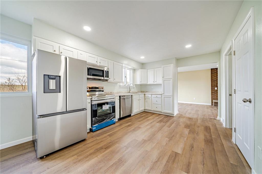 608 Fitz Henry Road Smithton, PA 15479 - Photo 3 of 40 a kitchen with wooden floors and stainless steel appliances