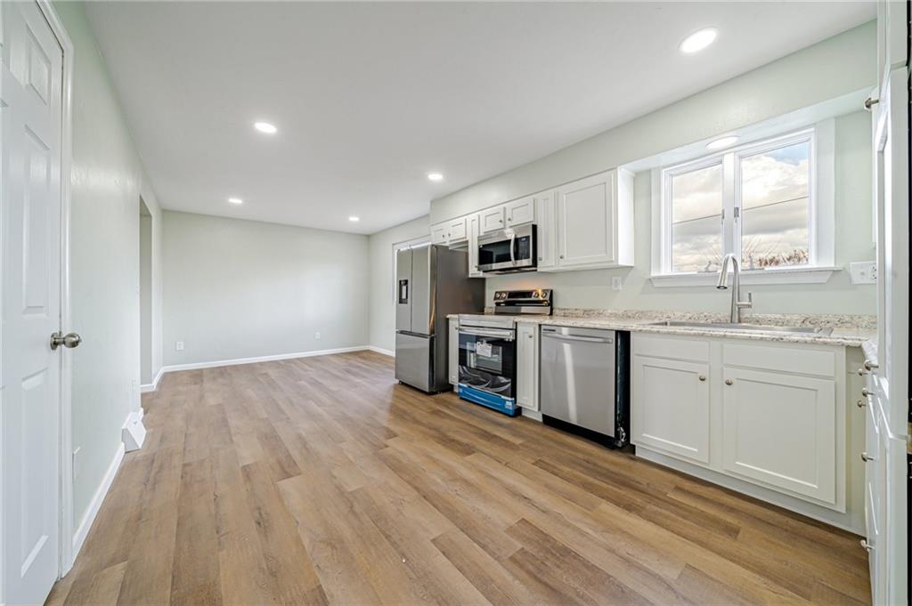 608 Fitz Henry Road Smithton, PA 15479 - Photo 5 of 40 a kitchen with stove cabinets and wooden floor