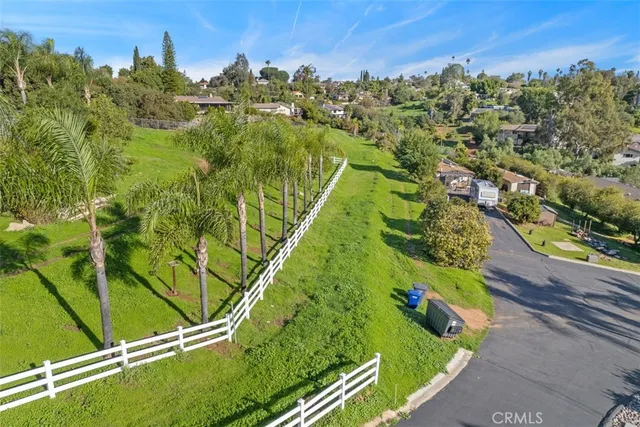 an aerial view of residential houses with outdoor space and trees