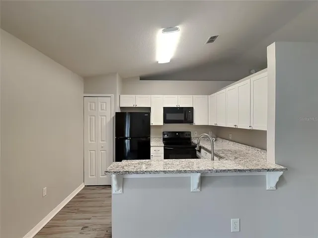 a kitchen with stainless steel appliances granite countertop a sink refrigerator and microwave