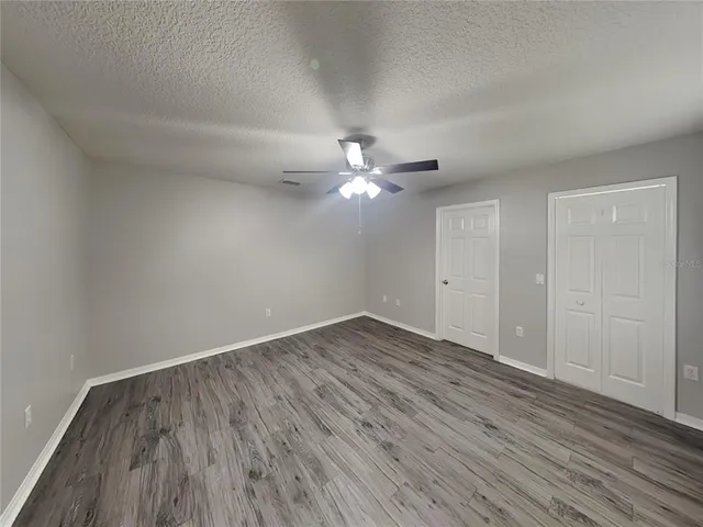wooden floor in an empty room with a fan
